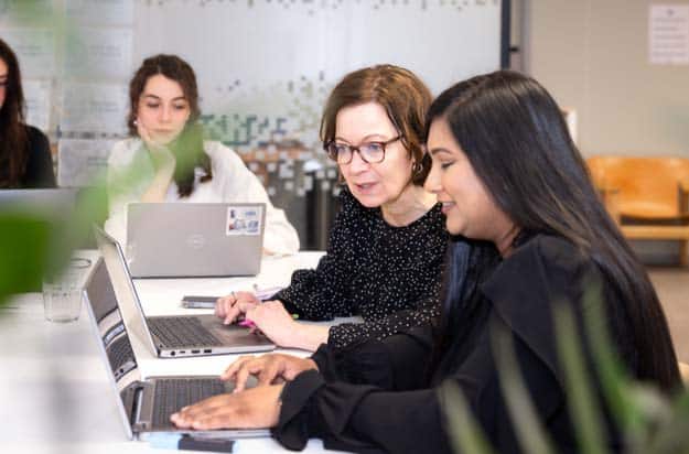 Collega's kijken met elkaar mee op het computerscherm