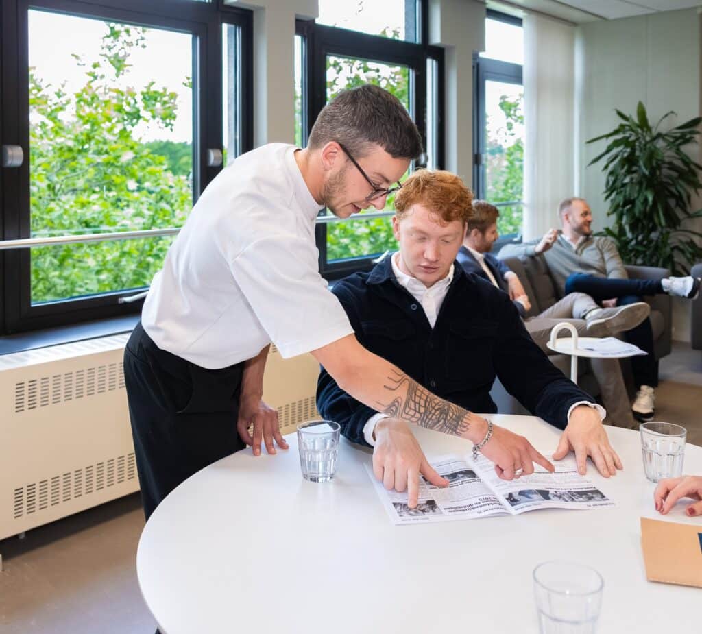 Collega geeft uitleg aan een andere collega