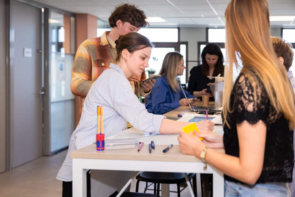 Trainees werken samen aan een poster