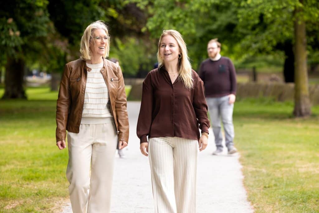 Collega's in gesprek tijdens een wandeling door het park