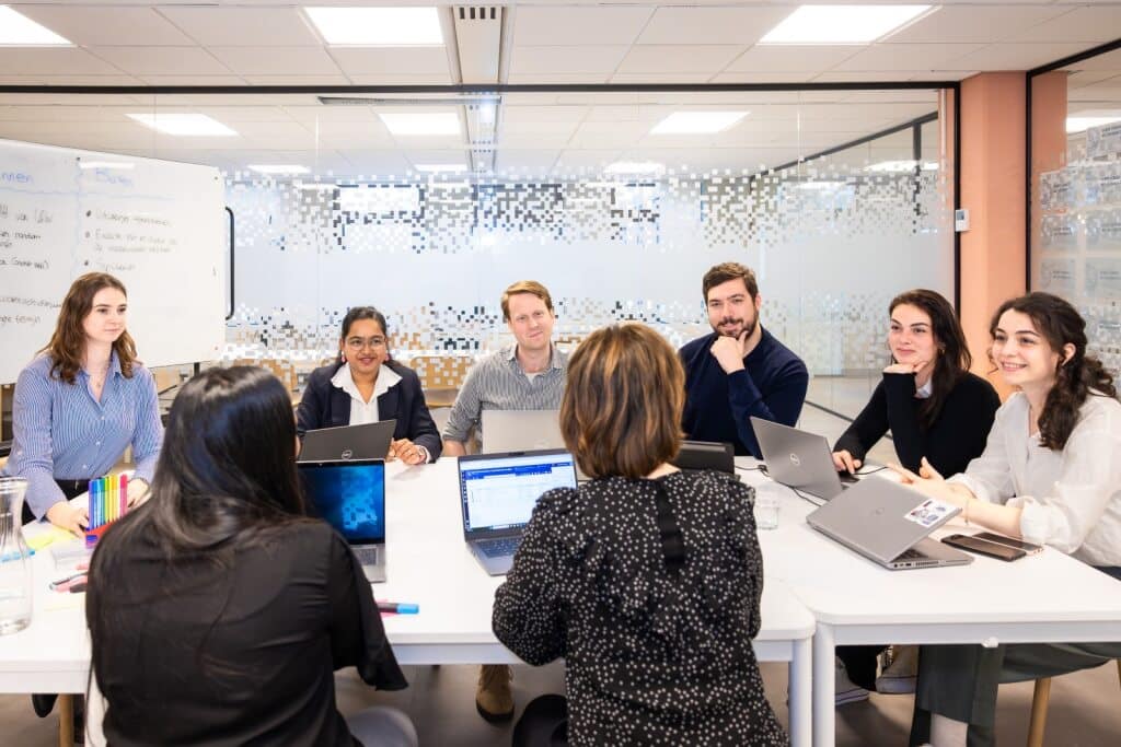 Groep collega's luistert naar uitleg van collega