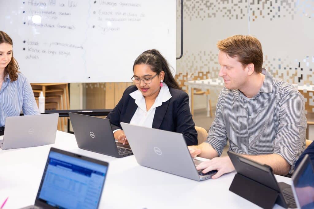 Collega's kijken gezamelijk naar hun computerscherm