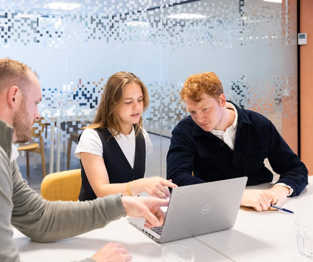 Collega's bespreken gezamenlijk document op de laptop